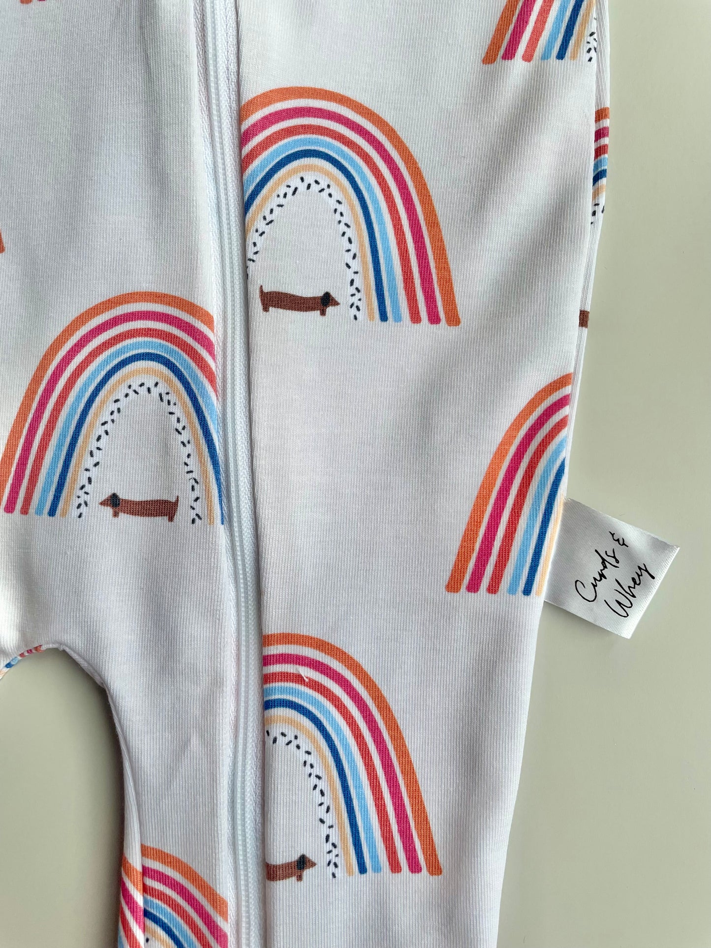 Sausage dog and rainbows zippy baby-grow
