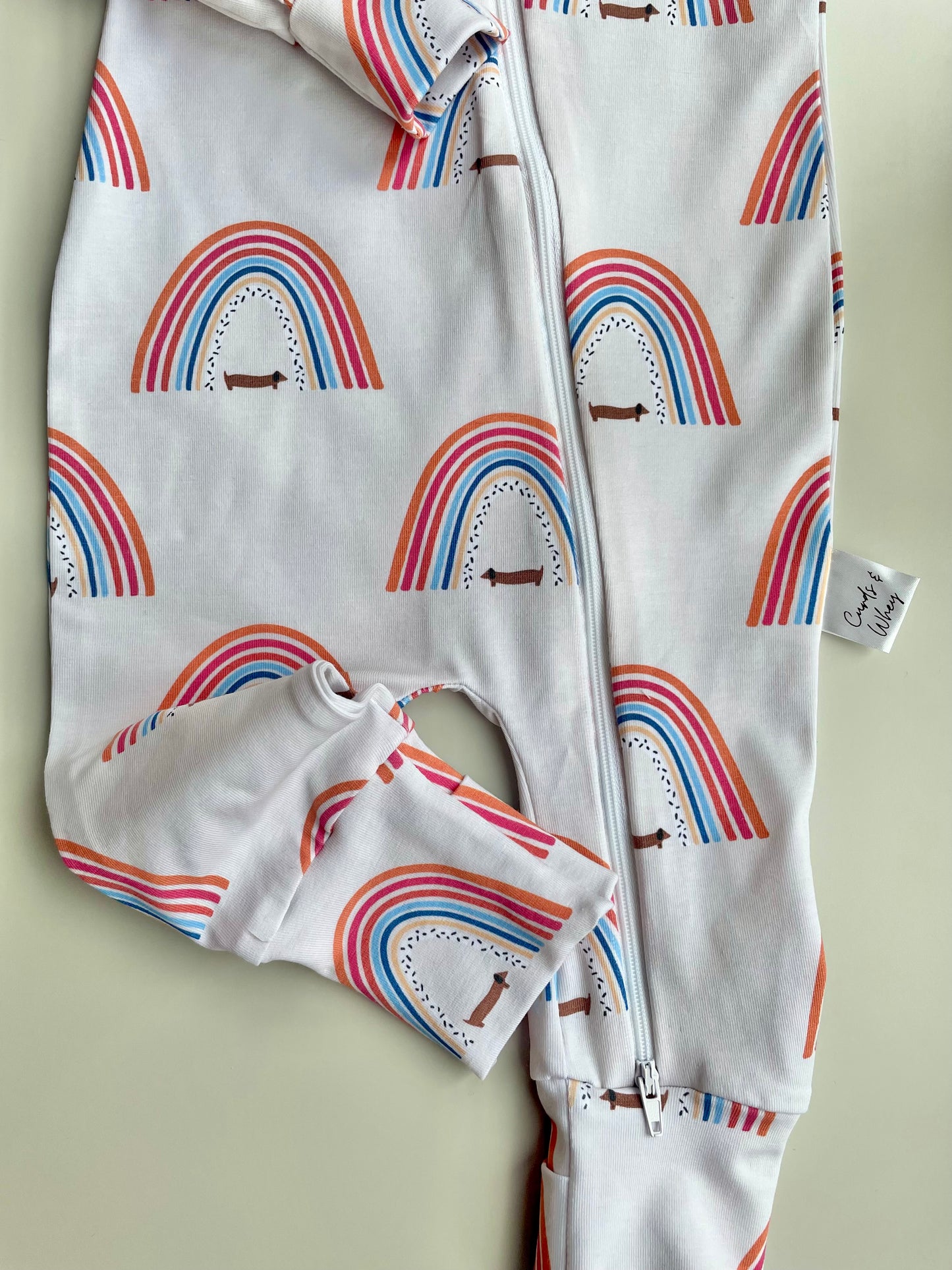 Sausage dog and rainbows zippy baby-grow