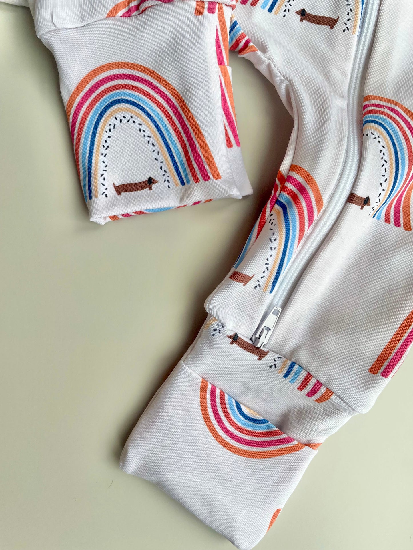 Sausage dog and rainbows zippy baby-grow
