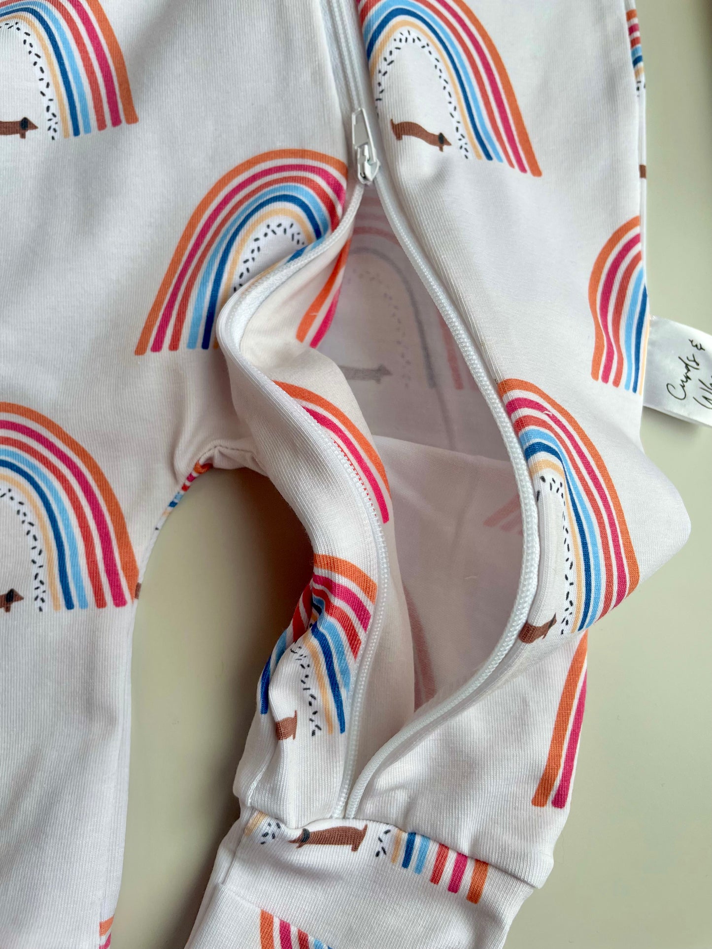 Sausage dog and rainbows zippy baby-grow